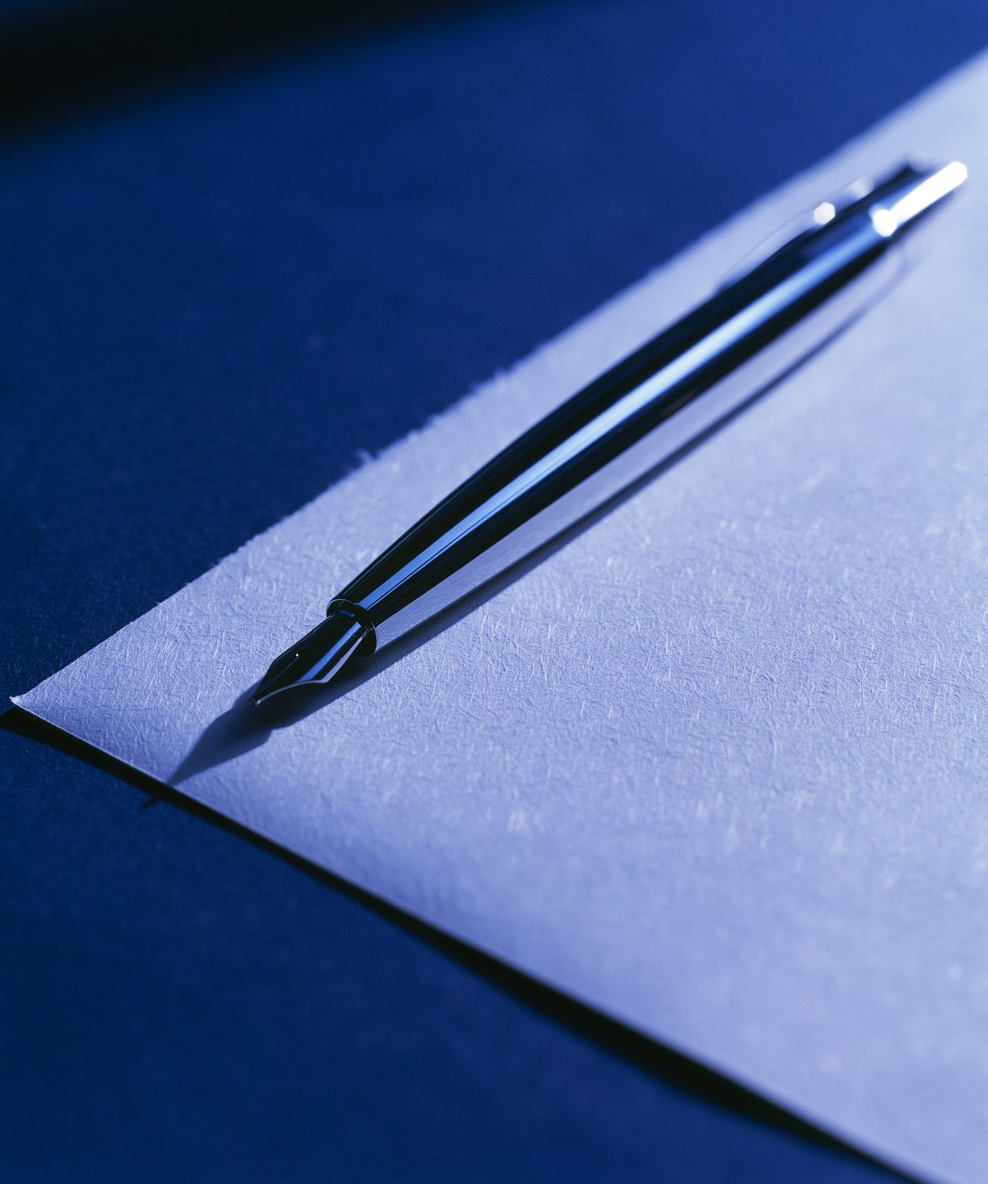Pluma estilográfica sobre un documento, luz rasante